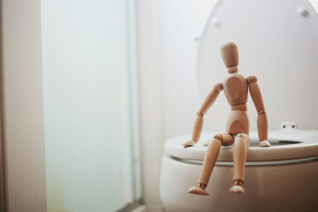 Houten poppetje op toilet  - giorgio-trovato-XatMS2NXIpo-unsplash